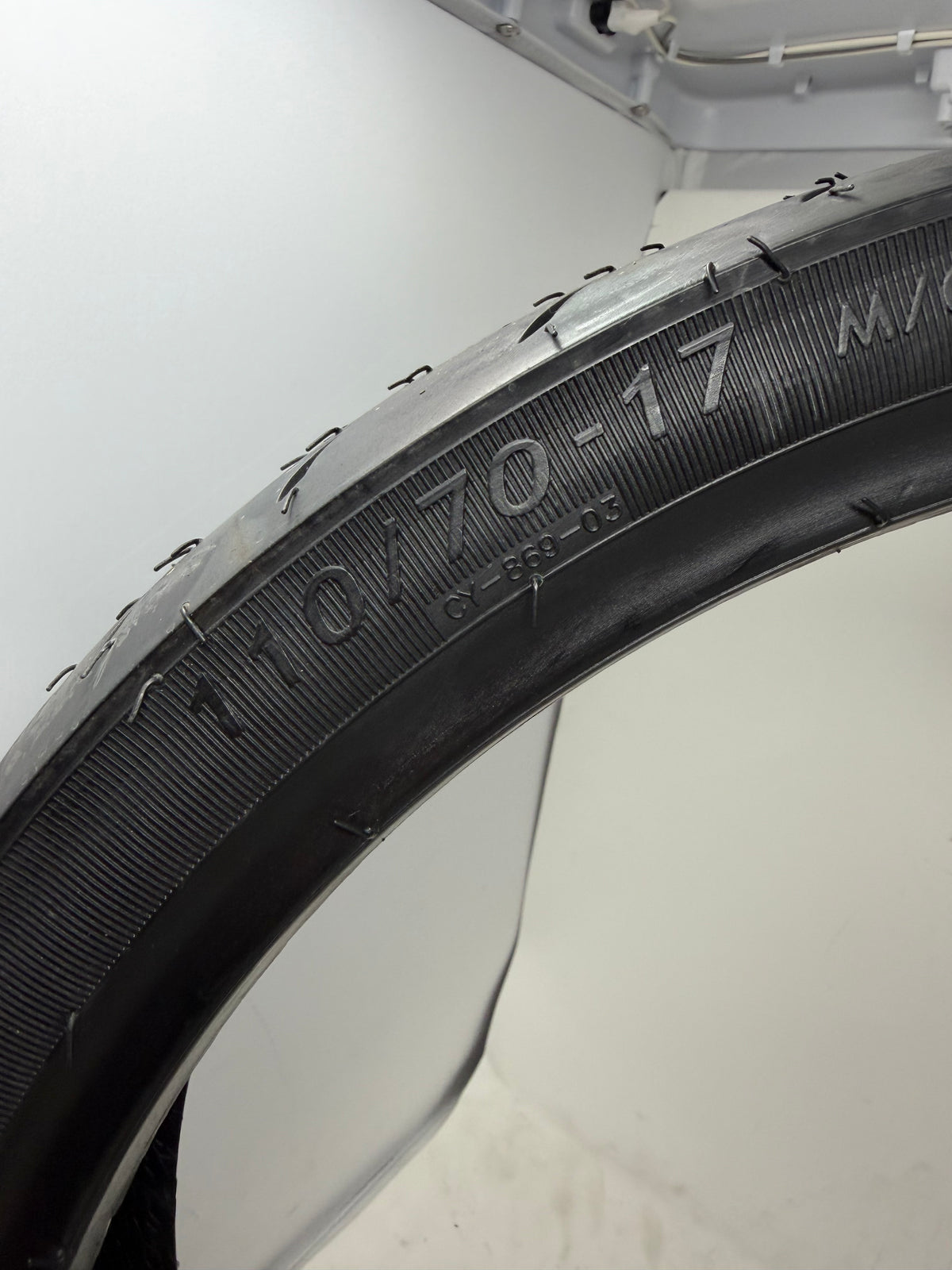 110/70-17 motorcycle tire, close-up of size and molded sidewall markings