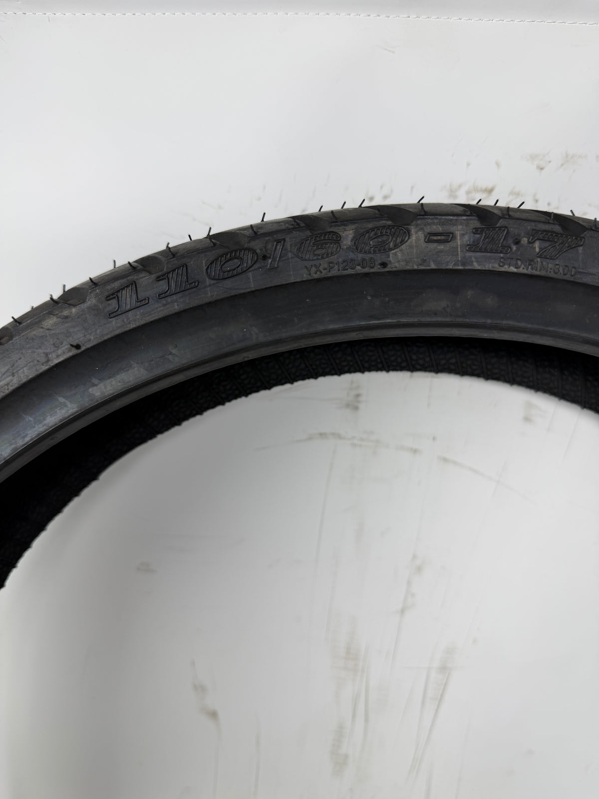 110/80-17 motorcycle tire, close-up of size and molded sidewall markings