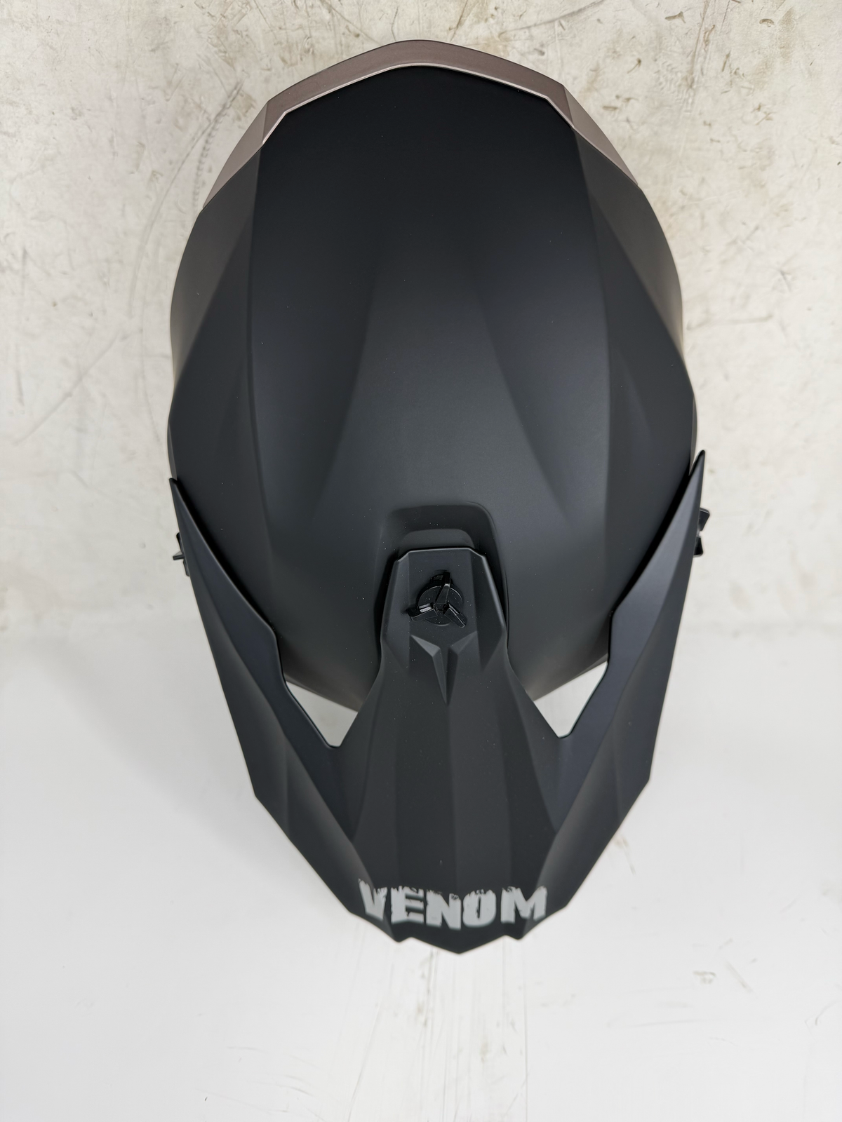 Top view of matte black dirt bike motocross ATV helmet and peak visor