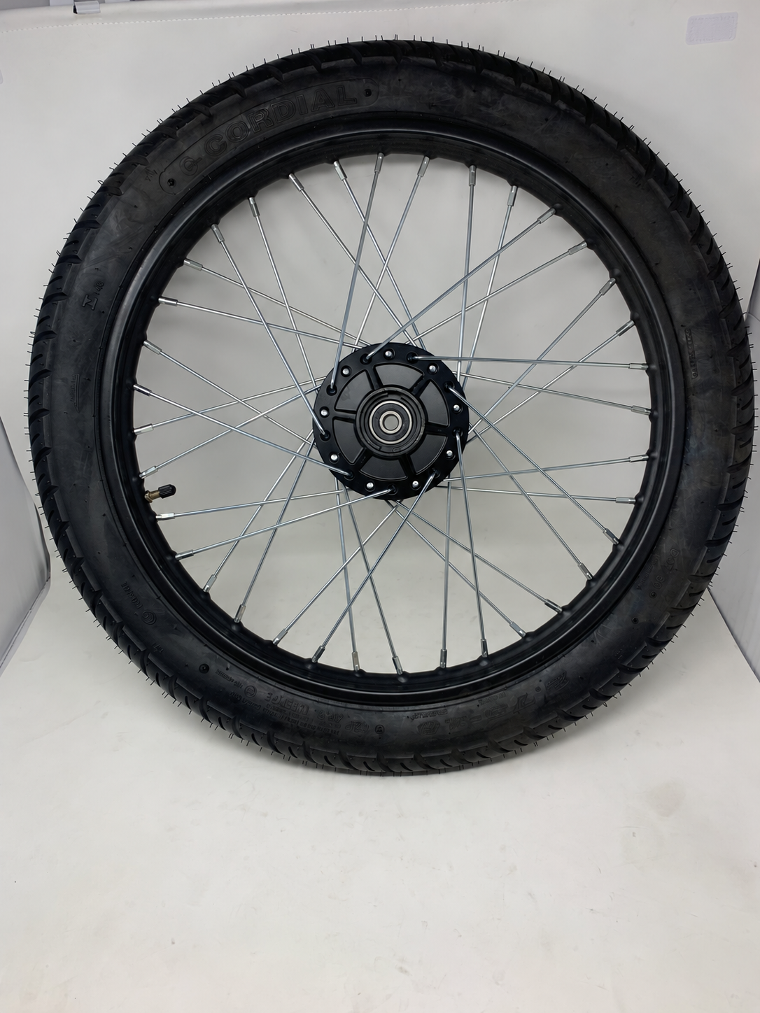Opposite side of the DF250RTG Sportster 250cc front tire and rim assembly showing silver spokes, hub and valve stem