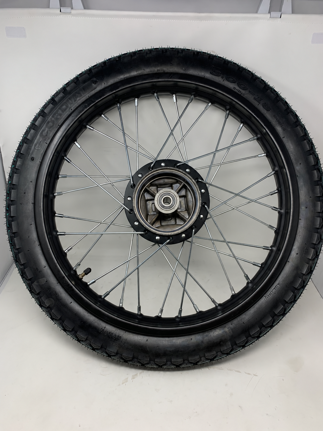 Drum side of the DF250RTG Sportster 250cc rear wheel and tire assembly showing the hub, silver spokes and valve stem