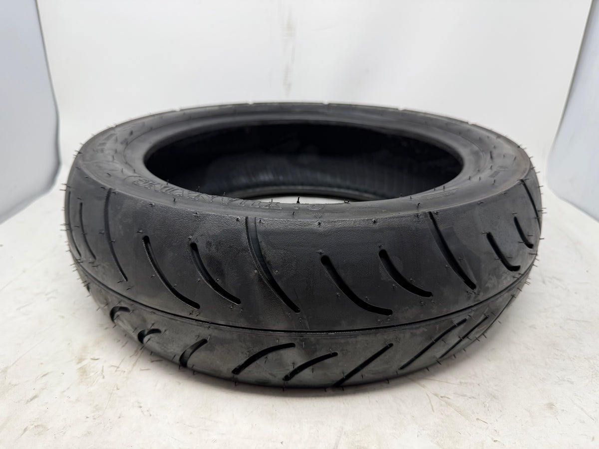 120/70-12 motorcycle tire, angled view showing tread pattern