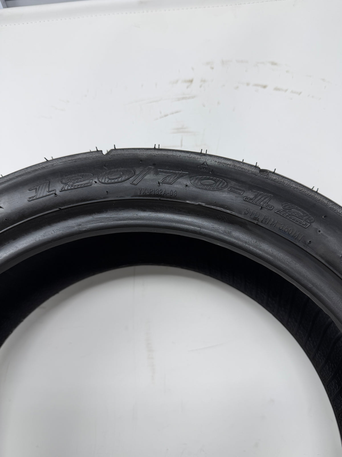 120/70-12 motorcycle tire, close-up of size and molded sidewall markings