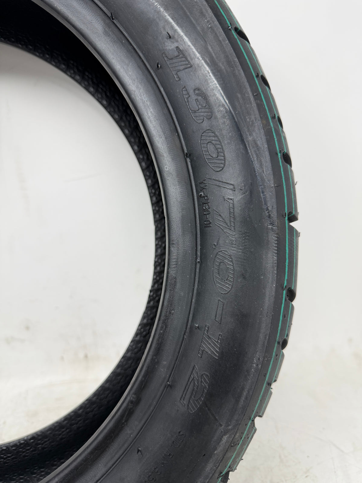 130/70-12 motorcycle tire, close-up of size and molded sidewall markings
