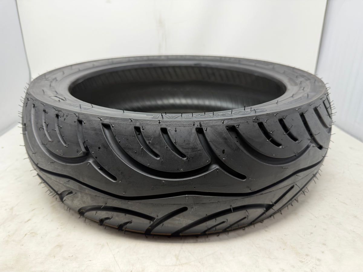 140/60-14 motorcycle tire, angled view showing tread pattern