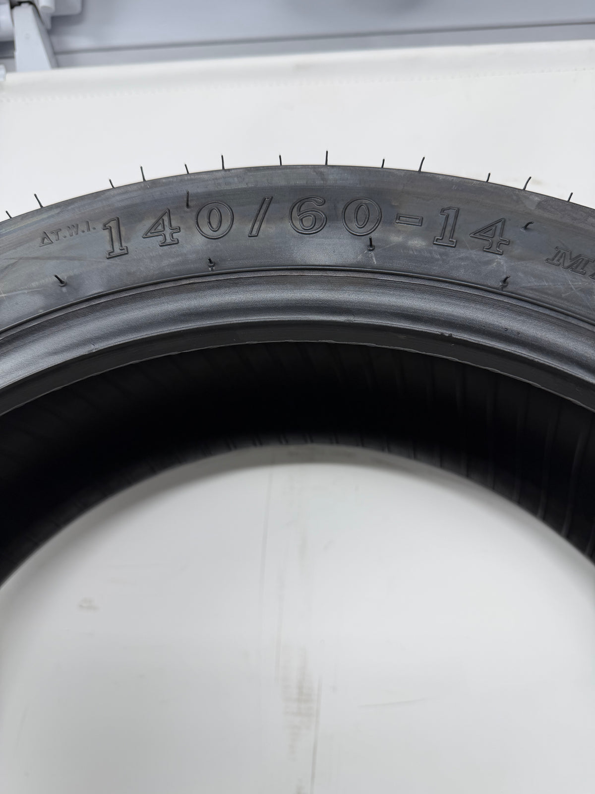 140/60-14 motorcycle tire, close-up of size and molded sidewall markings