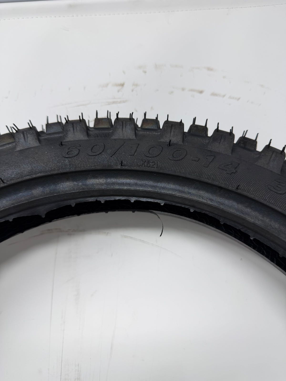 60/100-14 motorcycle tire, close-up of size and molded sidewall markings