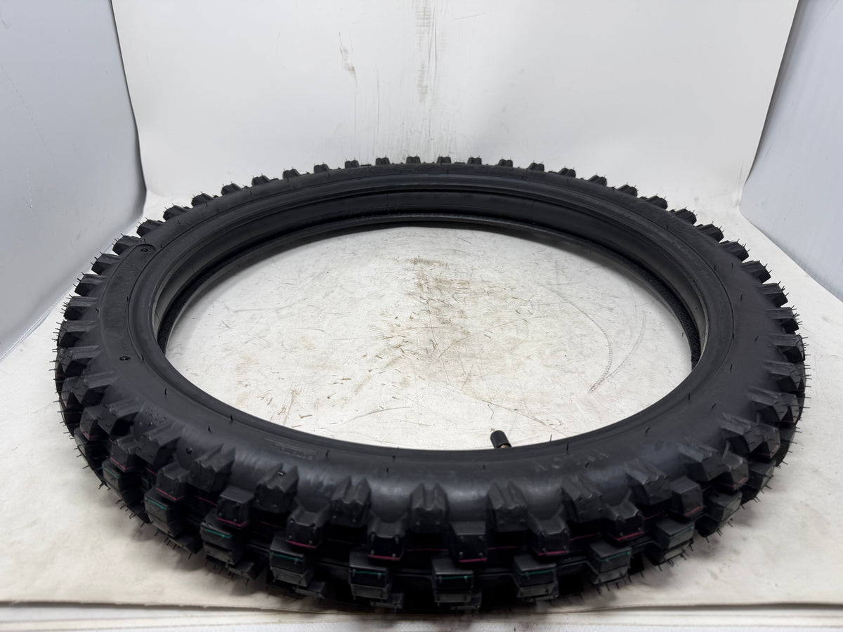 70/100-17 motorcycle tire, angled view showing tread pattern, with inner tube and valve stem visible