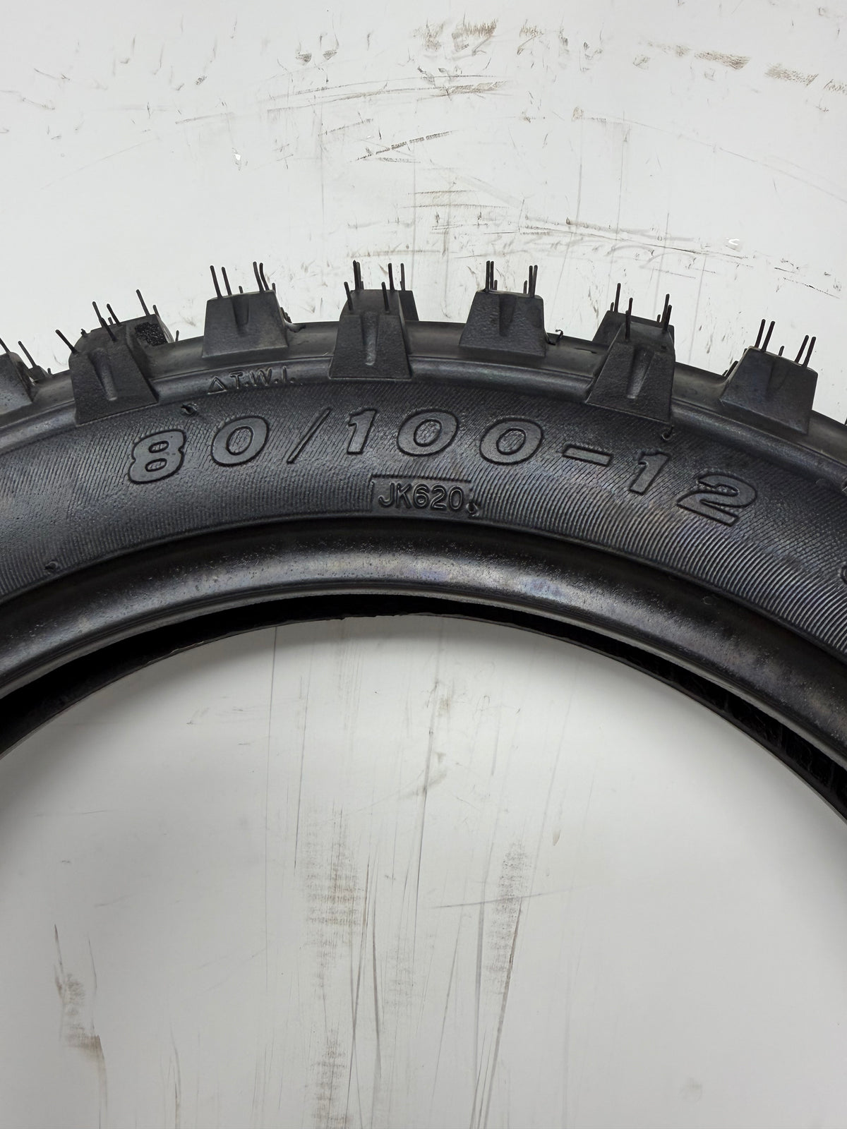 80/100-12 motorcycle tire, close-up of size and molded sidewall markings