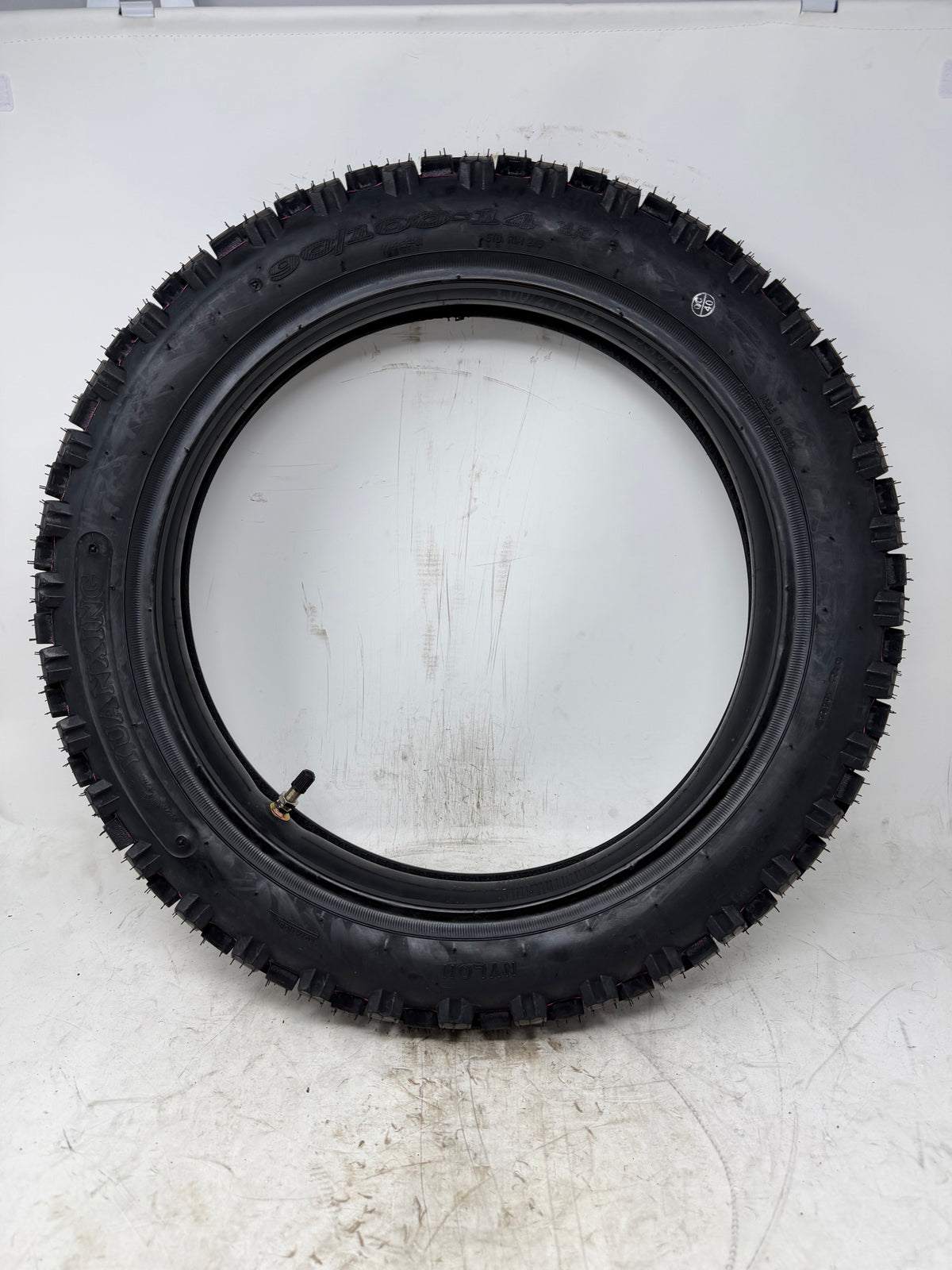 90/100-14 motorcycle tire, full sidewall view, with inner tube and valve stem visible