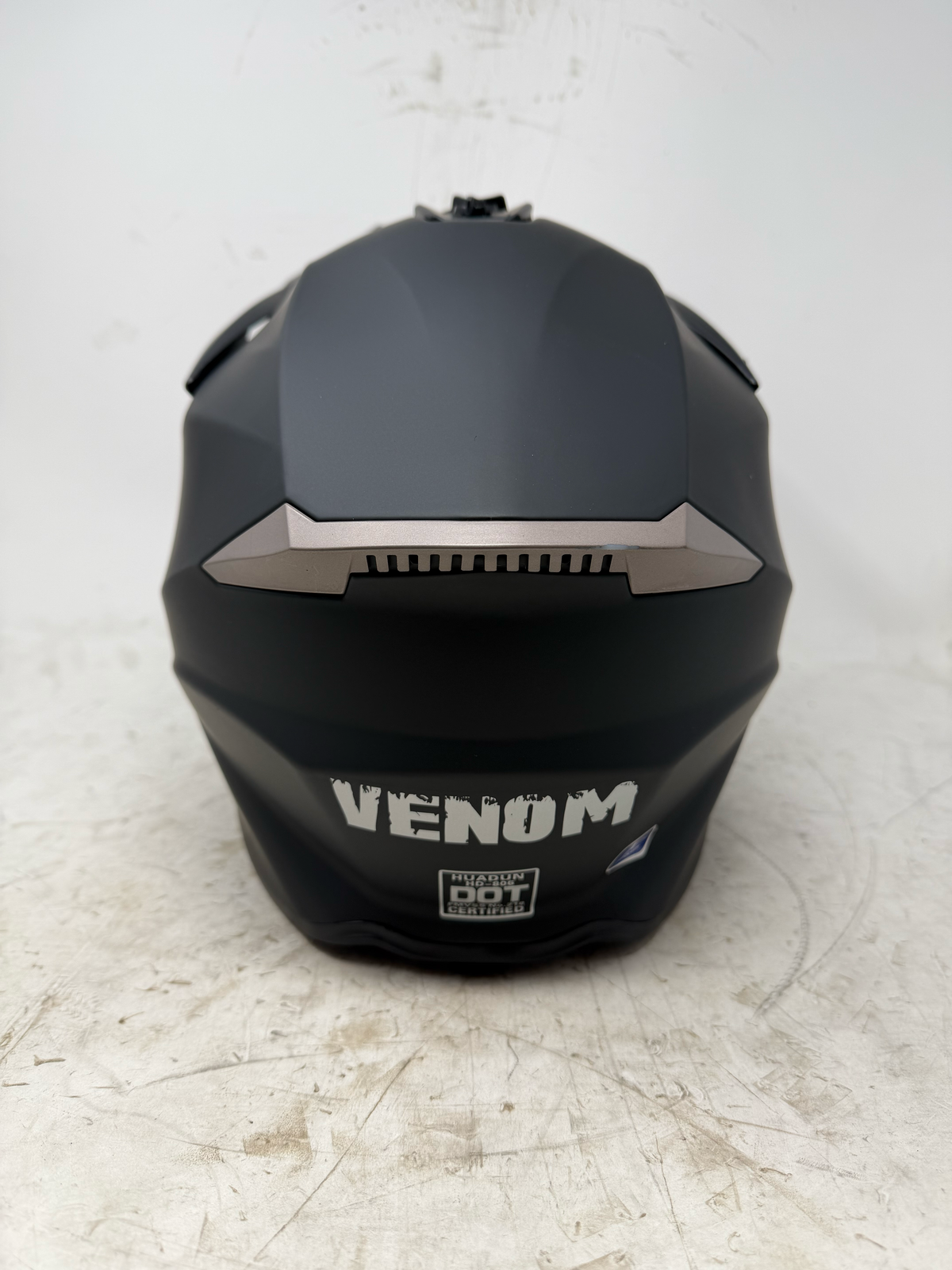 Rear view of black dirt bike ATV helmet with DOT certification label