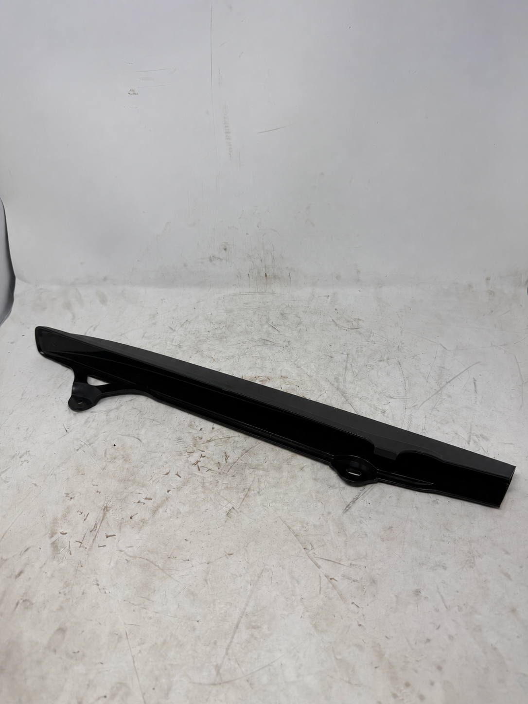 Black chain guard for DF250RTG Sportster 250cc motorcycle, underside view showing two mounting tabs
