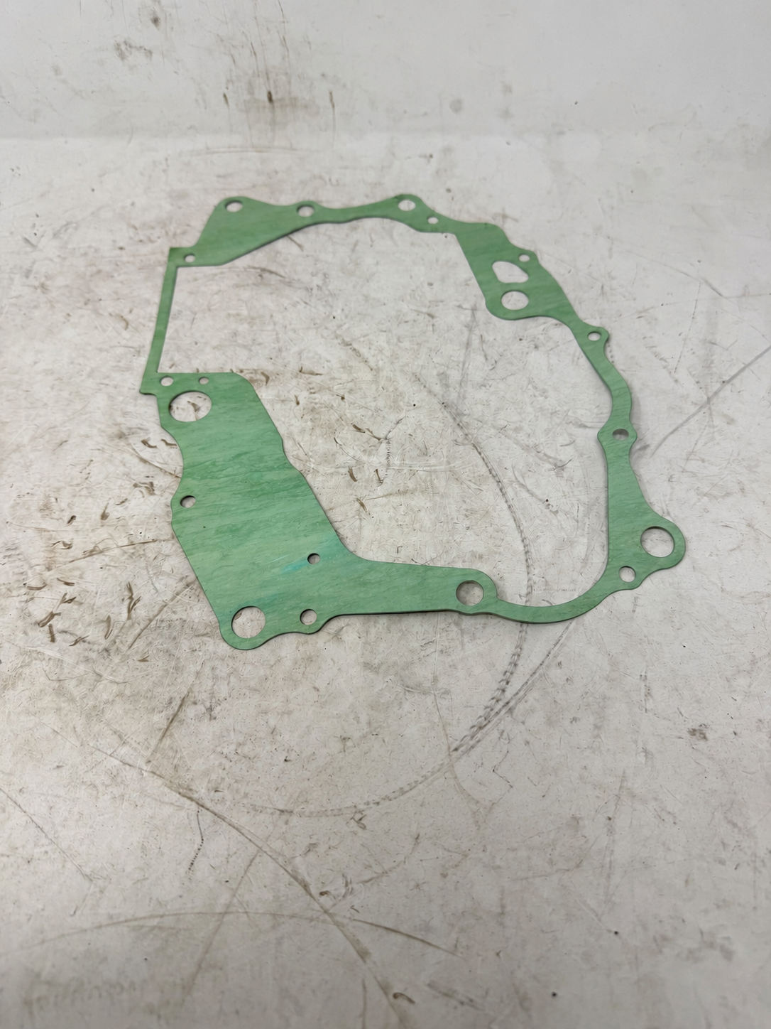 Green center crankcase gasket for DF250RTG Sportster 250cc motorcycle, showing irregular outline and engine passages